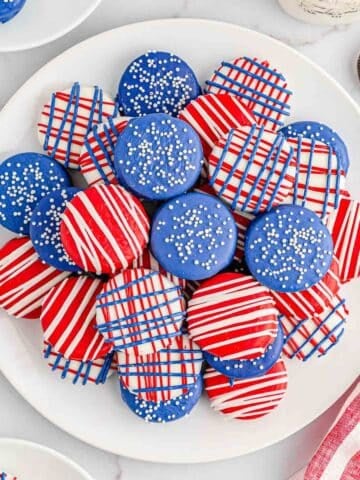 Multiple patriotic oreos stacked on a large white plate.