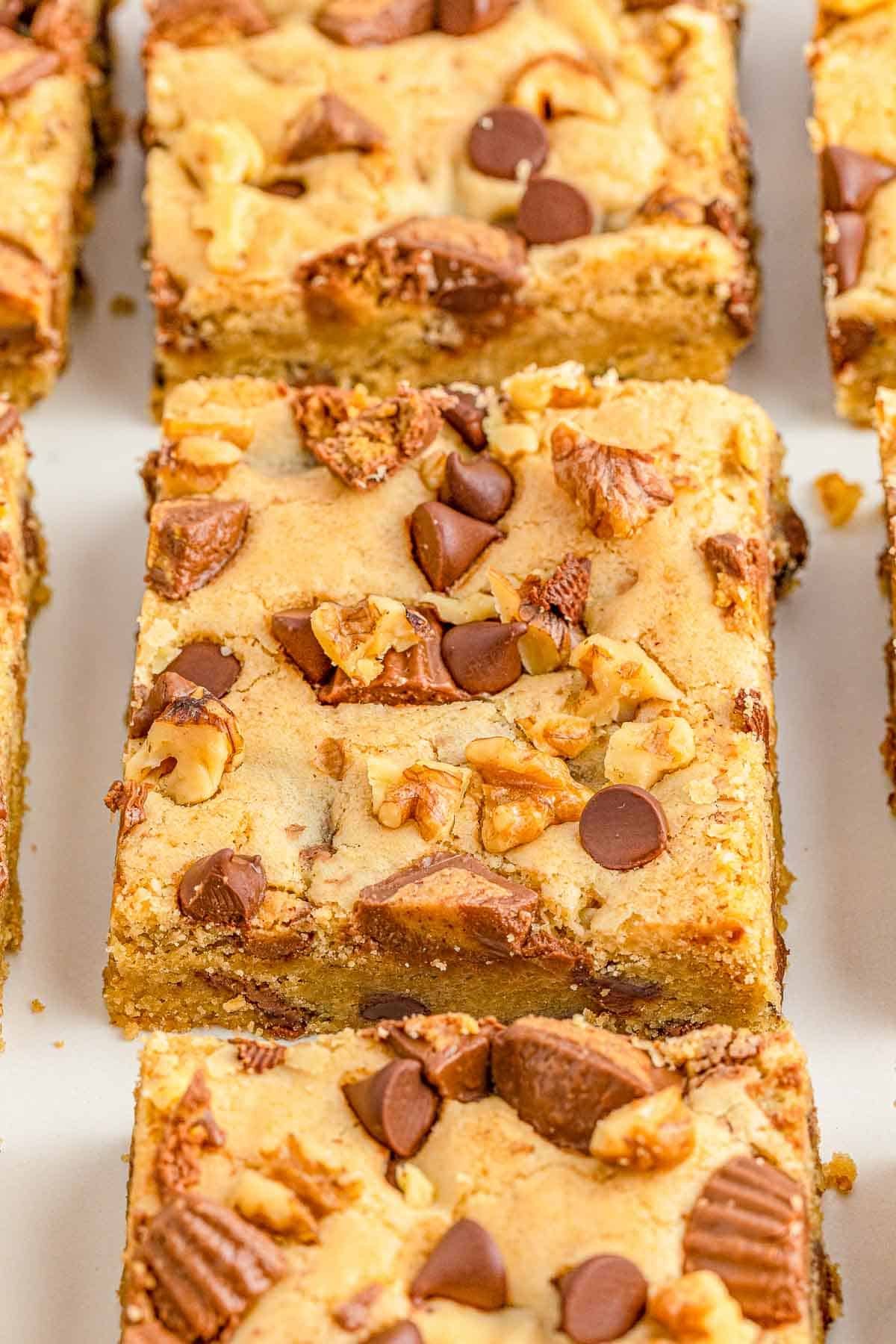 closeup of peanut butter cup cookie bars cut on a plate.