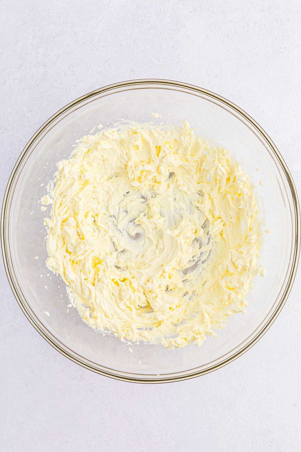 glass mixing bowl of creamed cream cheese.
