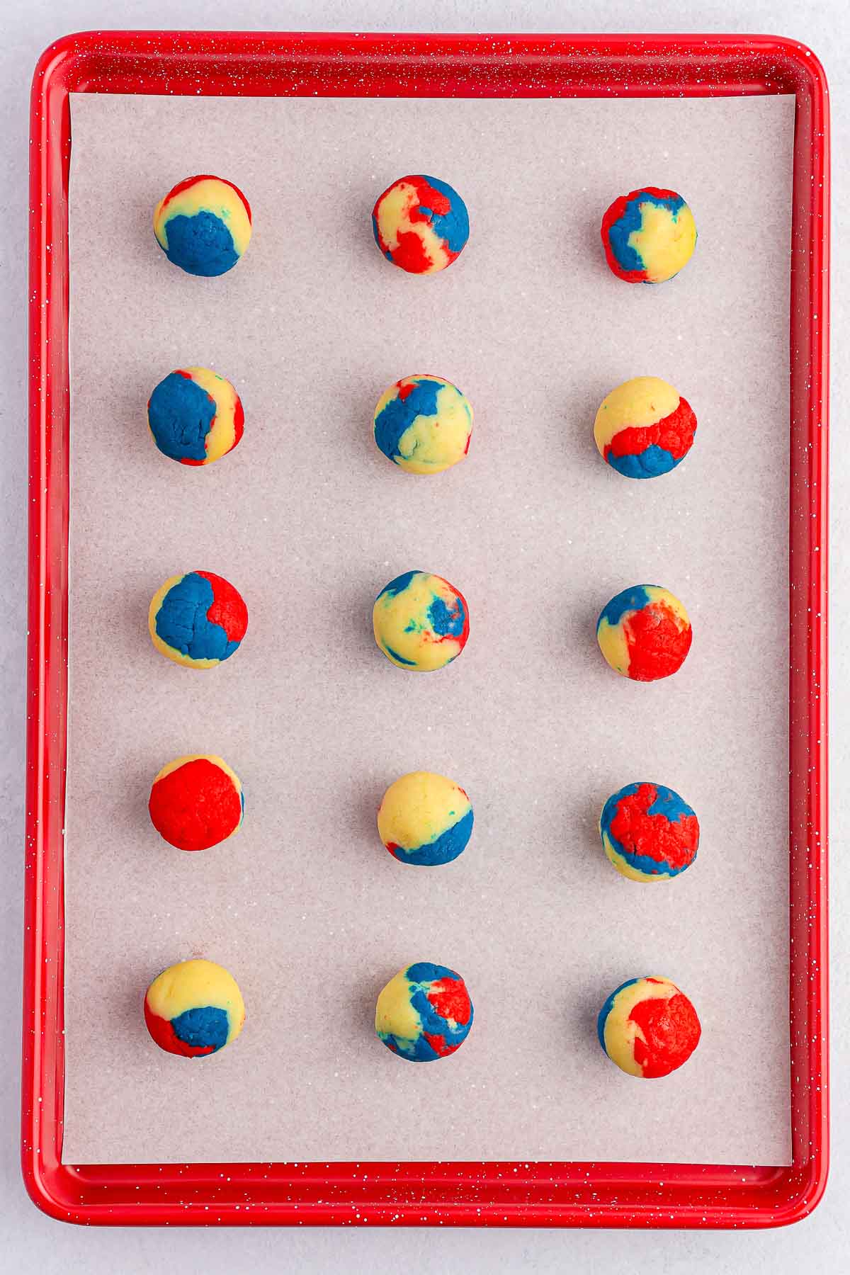 baking sheet with rolled red white and blue cake balls.
