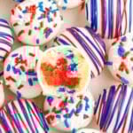 closeup of patriotic cake balls with red white and blue sprinkles and red and blue drizzle.