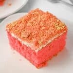 Slice of strawberry crunch cake on a white plate.