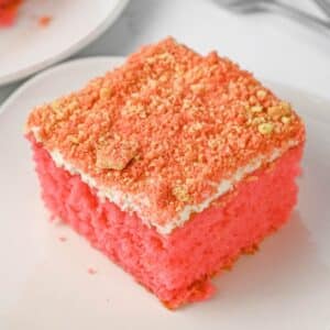 Slice of strawberry crunch cake on a white plate.