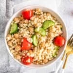 Mediterranean couscous salad in a white bowl.