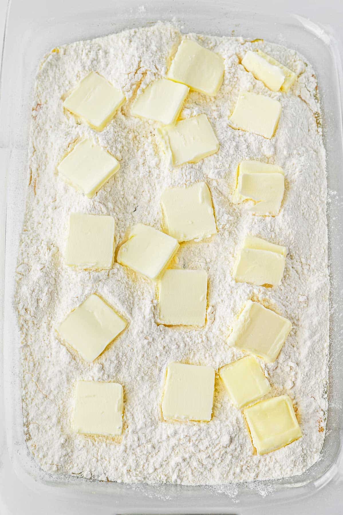 Butter slices laid over cake mix.