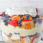 layered fruit trifle with angle food cake, blueberries, strawberries and cheesecake pudding layer with text over that read Easy Fruit Trifle.