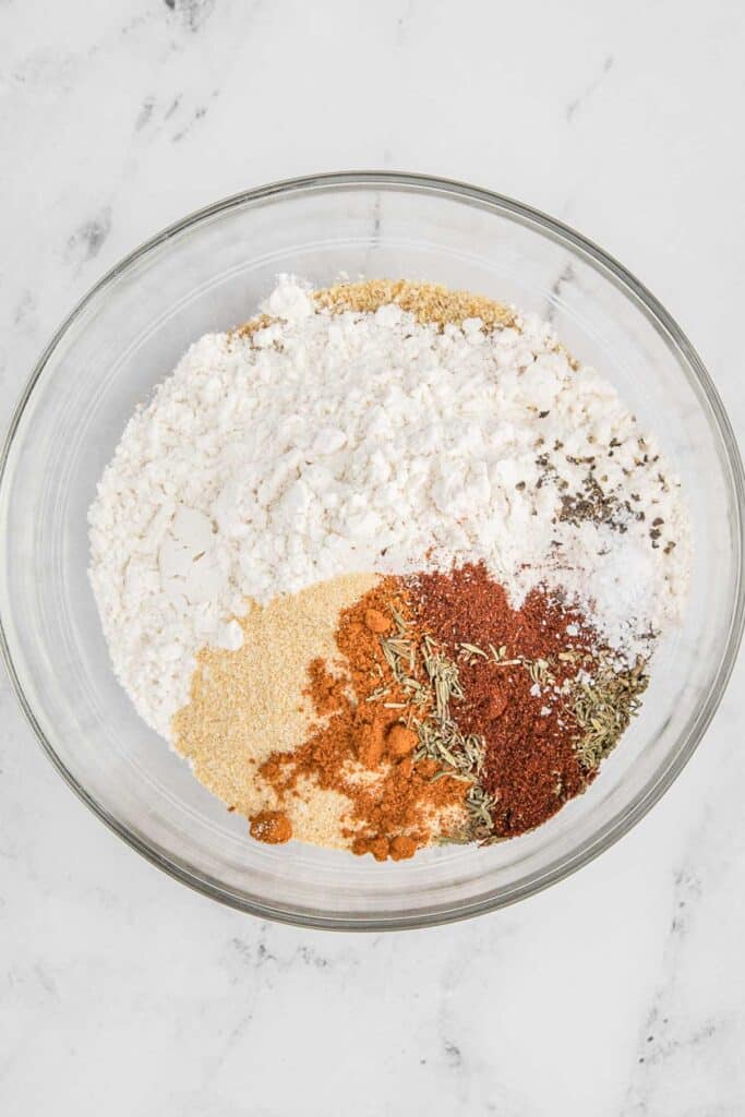Breadcrumbs and spices in a large glass bowl.