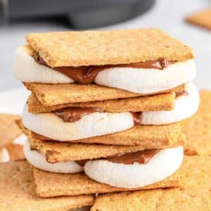 Stack of multiple smores on a large white plates.