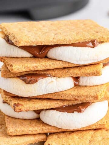 Stack of multiple smores on a large white plates.