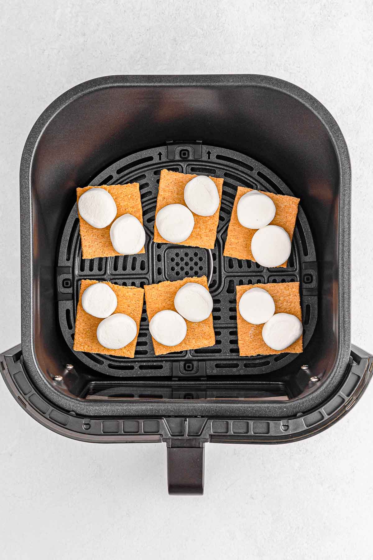 Six graham crackers with marshmallows in air fryer.