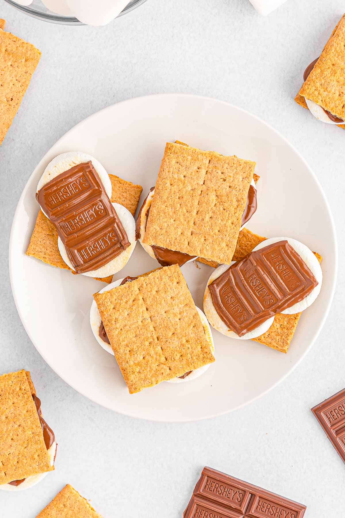 Four smores on a white plate.