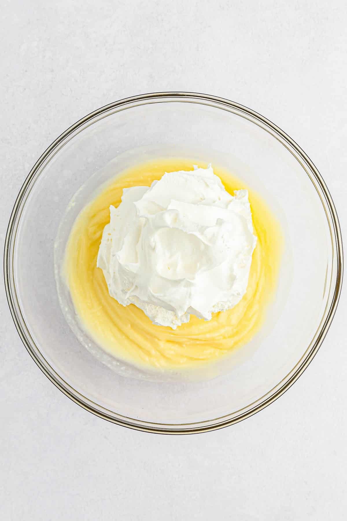Cool whip on top of vanilla pudding in a large class bowl.