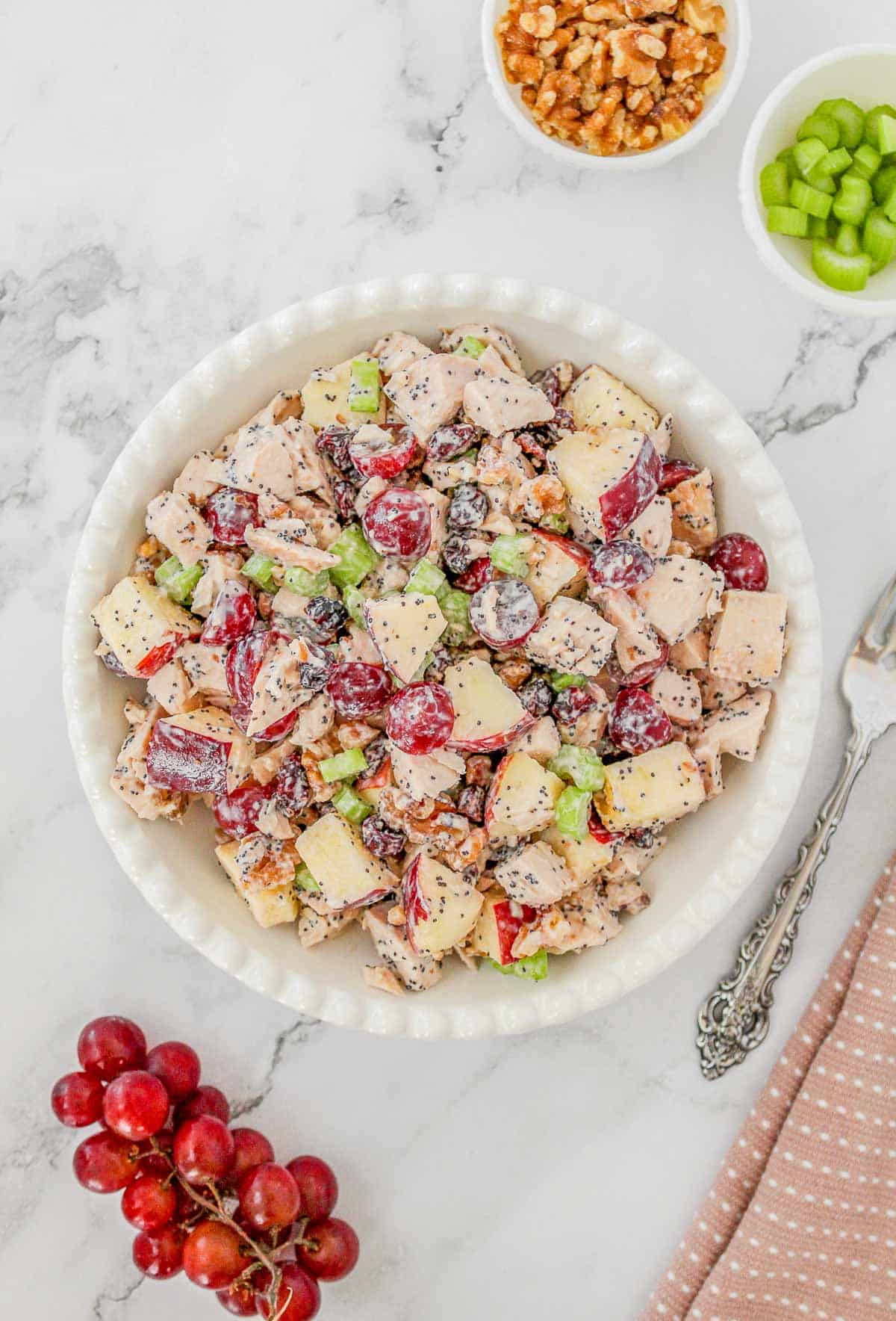 Chicken salad with grapes served in a white bowl.
