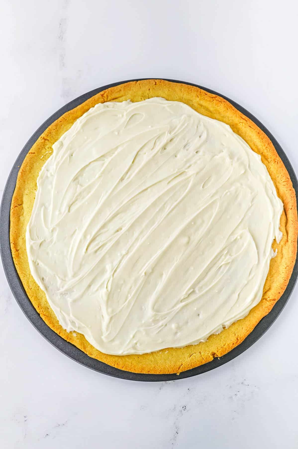 Cream cheese mixture spread over cookie crust on pizza pan.