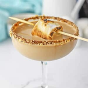 S'mores martini in glass topped with toasted marshmallow.