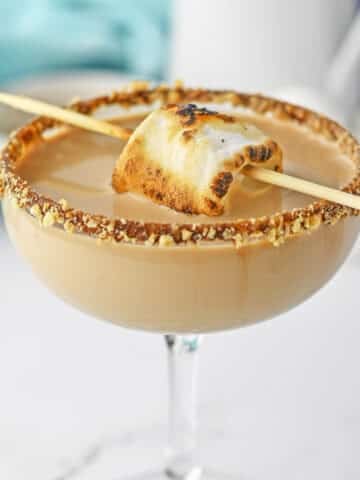 S'mores martini in glass topped with toasted marshmallow.