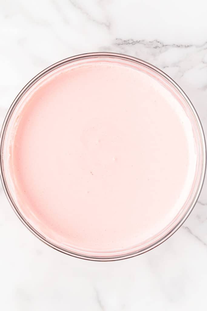 Pink strawberry jello in mixing bowl.