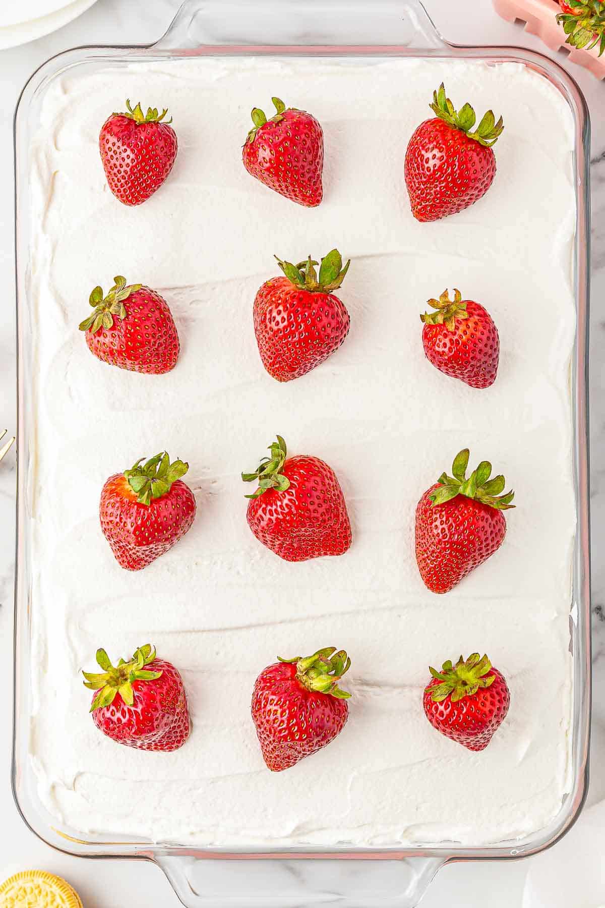 Strawberry delight in baking dish topped with whole strawberry.