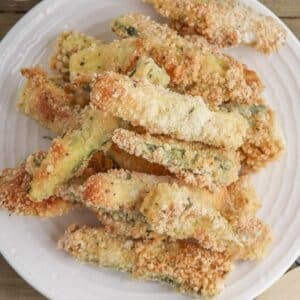 Pile of zucchini fries on a small white plate.