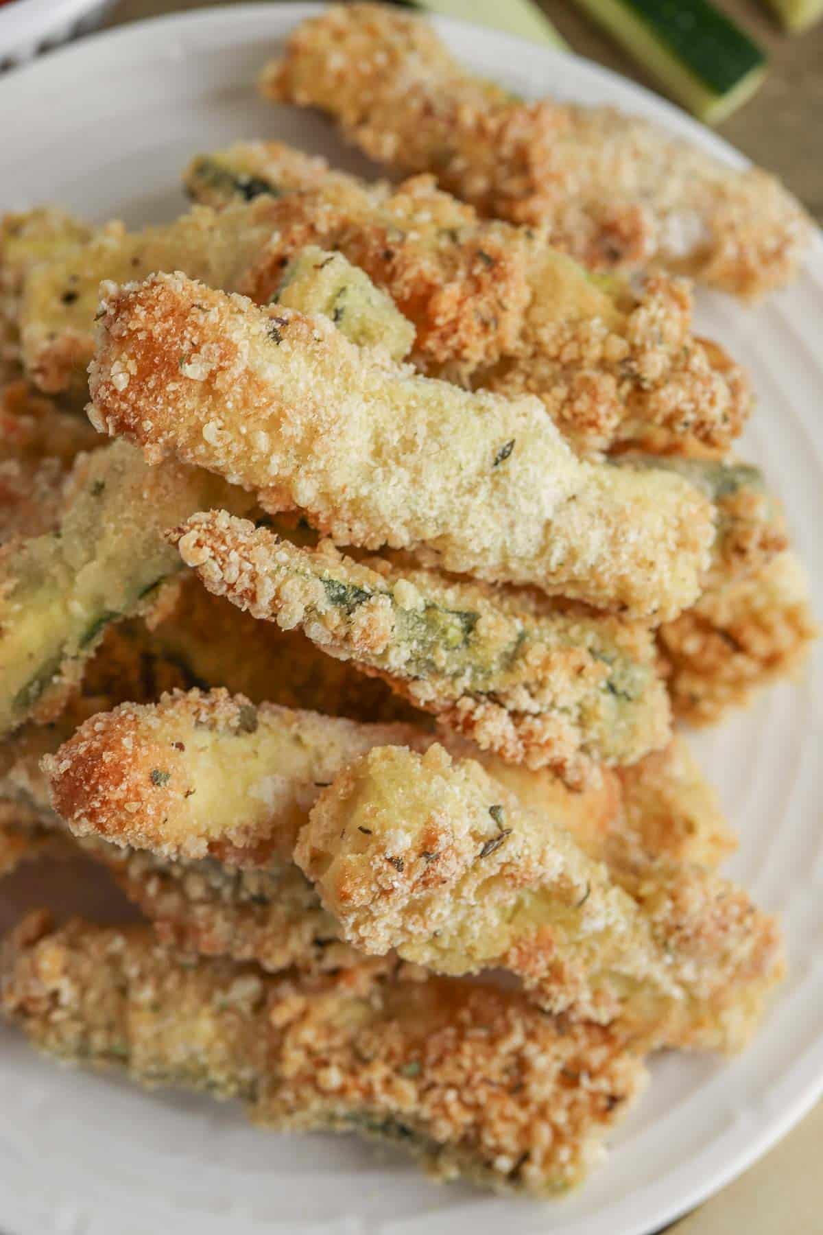 Pile of zucchini fries on a small white plate.
