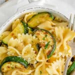 Lemon zucchini pasta in a white bowl with a fork on the side.