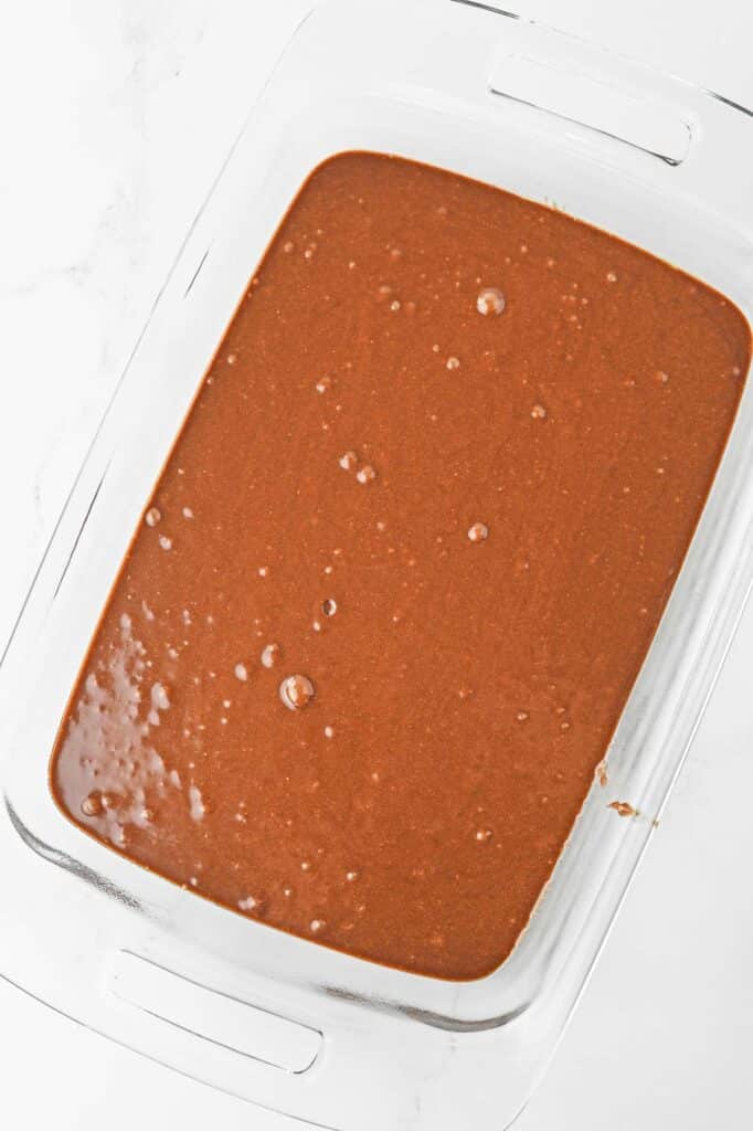 A glass baking dish with chocolate brownie mix.