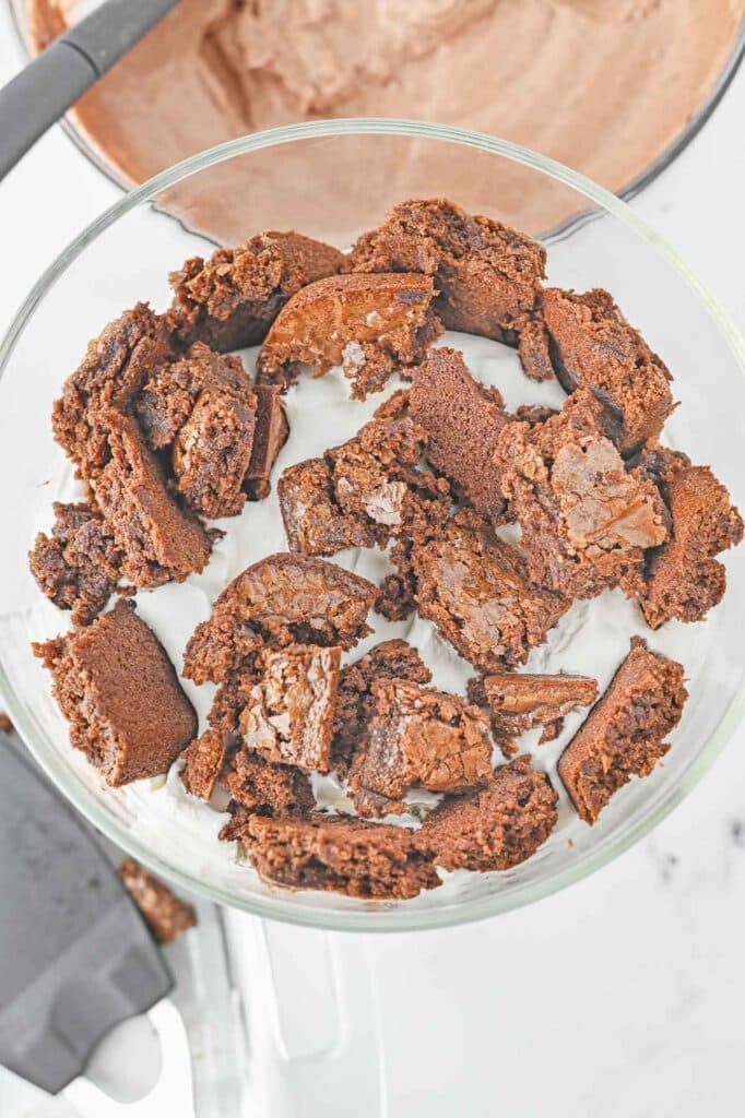 A large glass bowl with a layer of chocolate brownies.