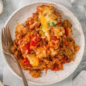 White plate of Cabbage roll casserole with a silver fork on the side.