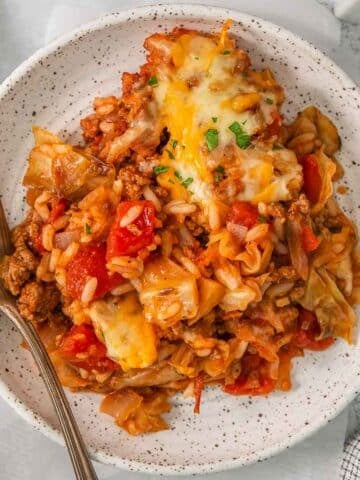 White plate of Cabbage roll casserole with a silver fork on the side.