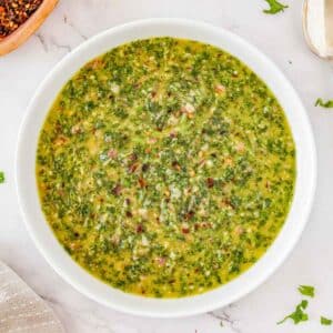 A white bowl filled with homemade chimichurri sauce.