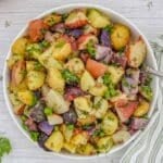 no mayo Potato salad with fresh herbs in a white bowl with a fork.