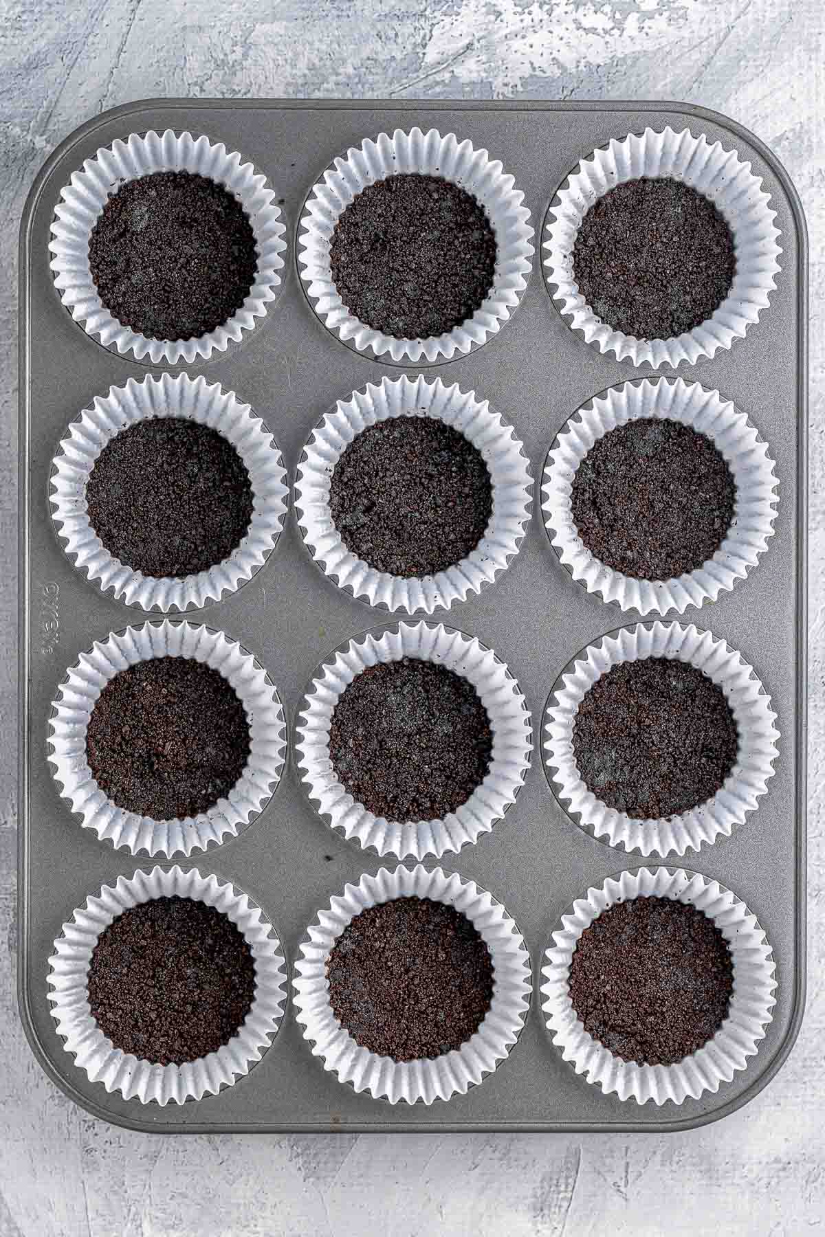 Oreo cookie crust in white muffin liners.
