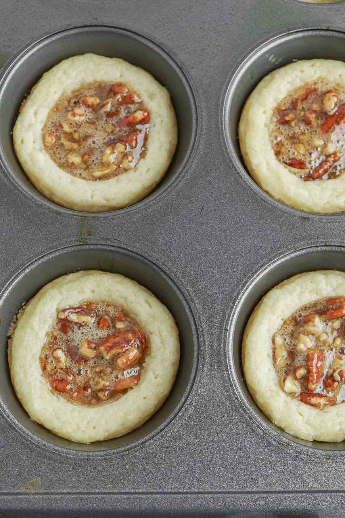 A muffin tin filled with pecan pie cookies.