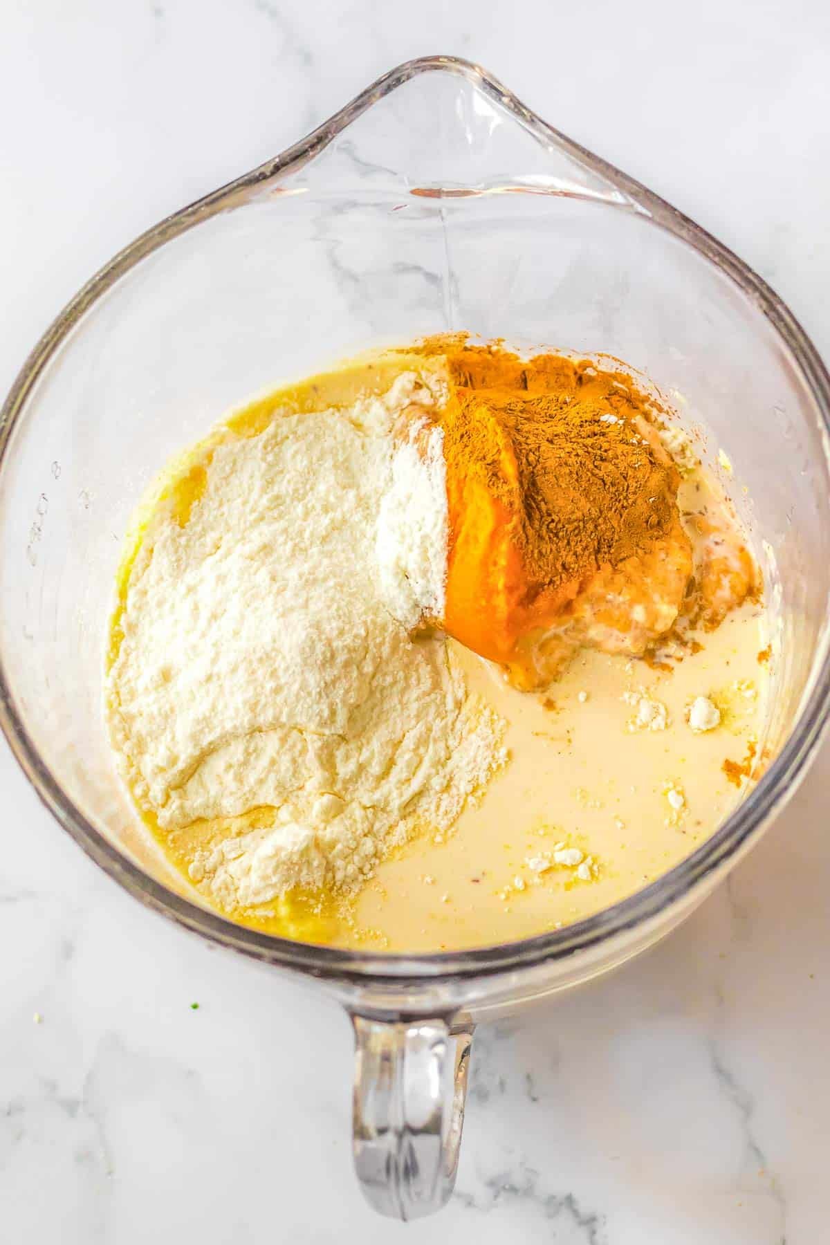 A glass bowl with pumpkin mix ingredients in it.
