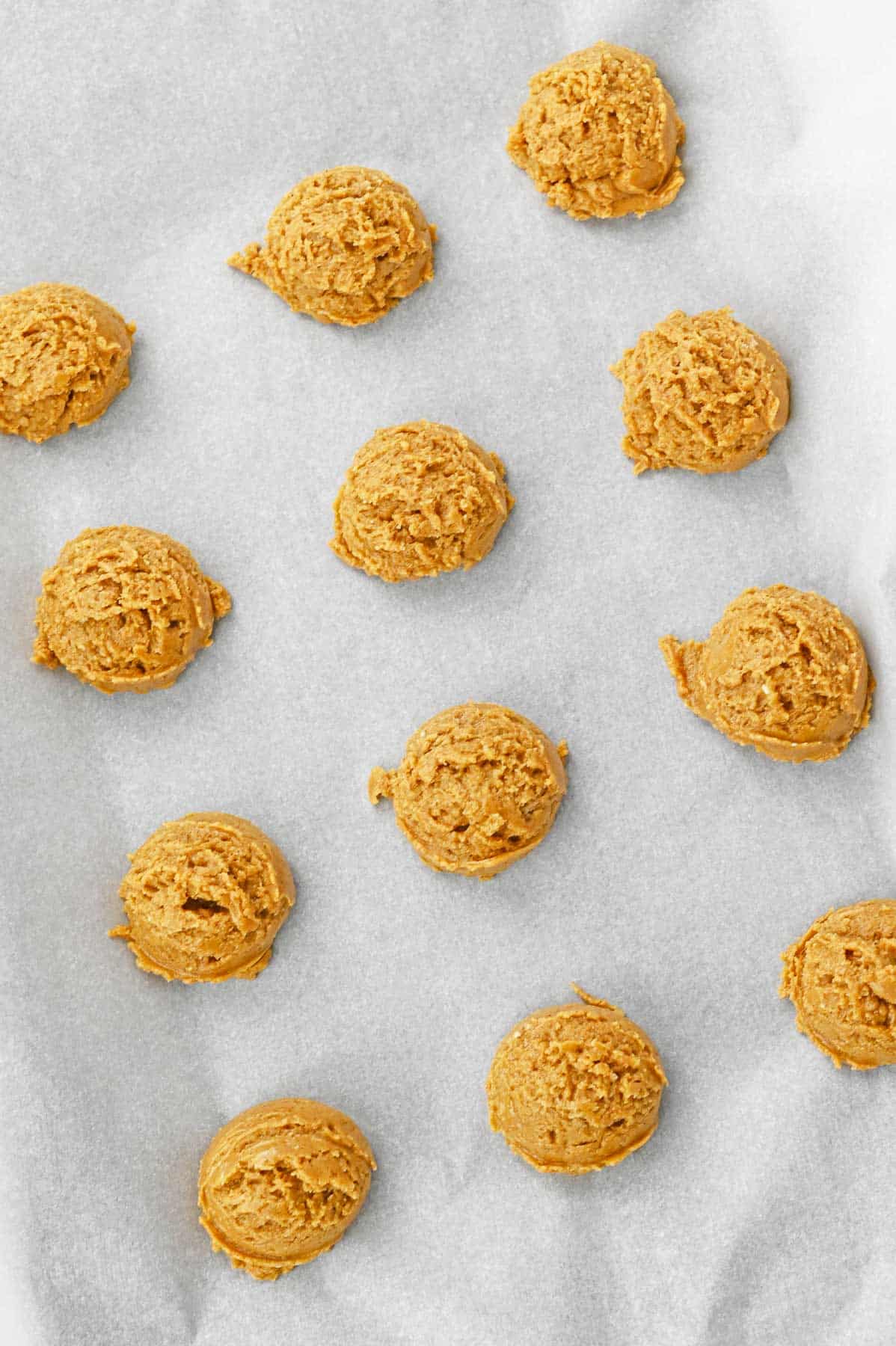 Pumpkin spice cookie dough balls on a baking sheet.