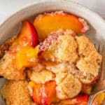 Easy peach cobbler in a bowl with a fork.