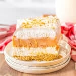 A slice of layered pumpkin delight on a white plate.