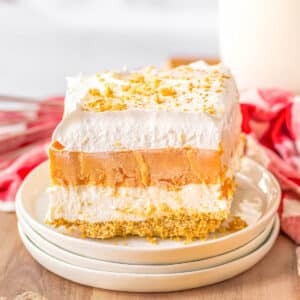 A slice of layered pumpkin delight on a white plate.