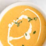 Yellow squash soup in a white bowl.