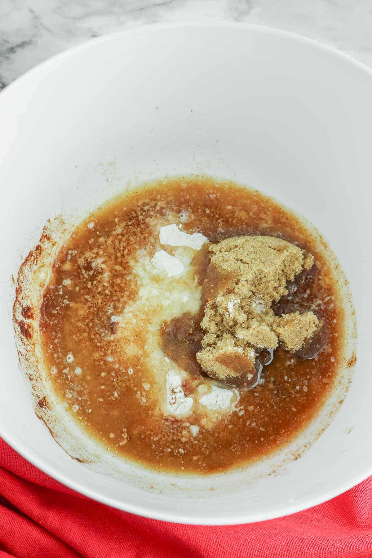 A white bowl consisting of flour, brown sugar, cinnamon, and butter.