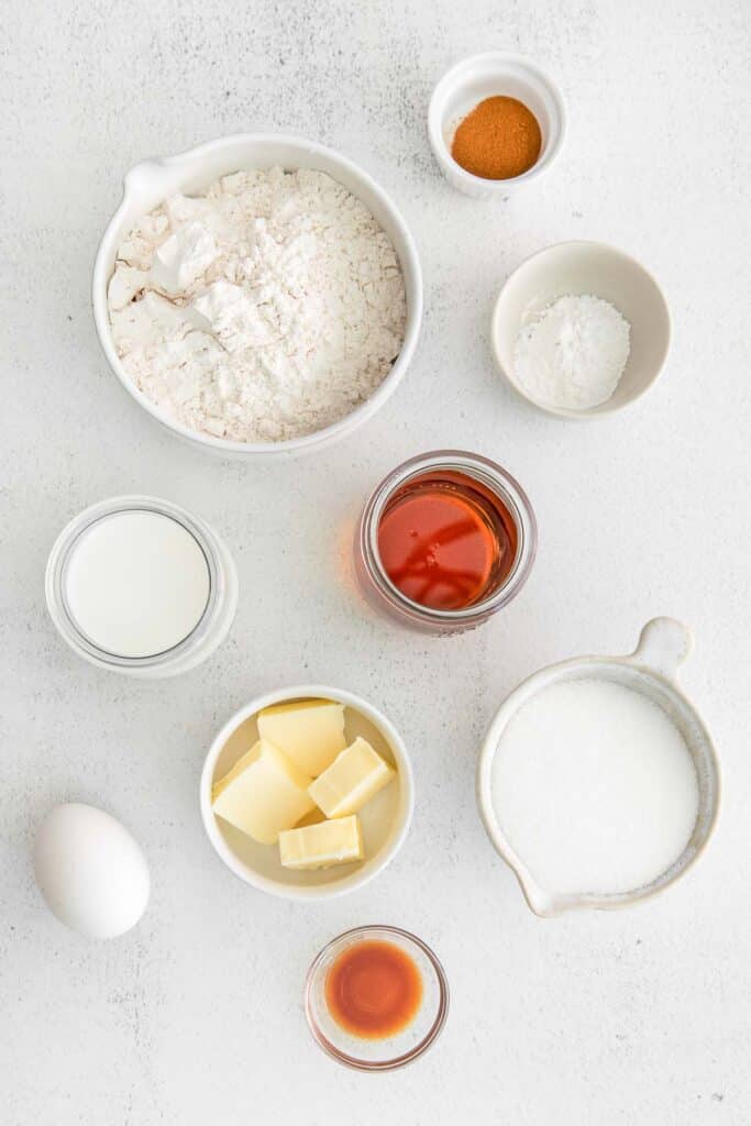 Ingredients for maple donuts - Flour, sugar, baking powder, ground cinnamon, milk, maple syrup, butter, eggs and vanilla extract.