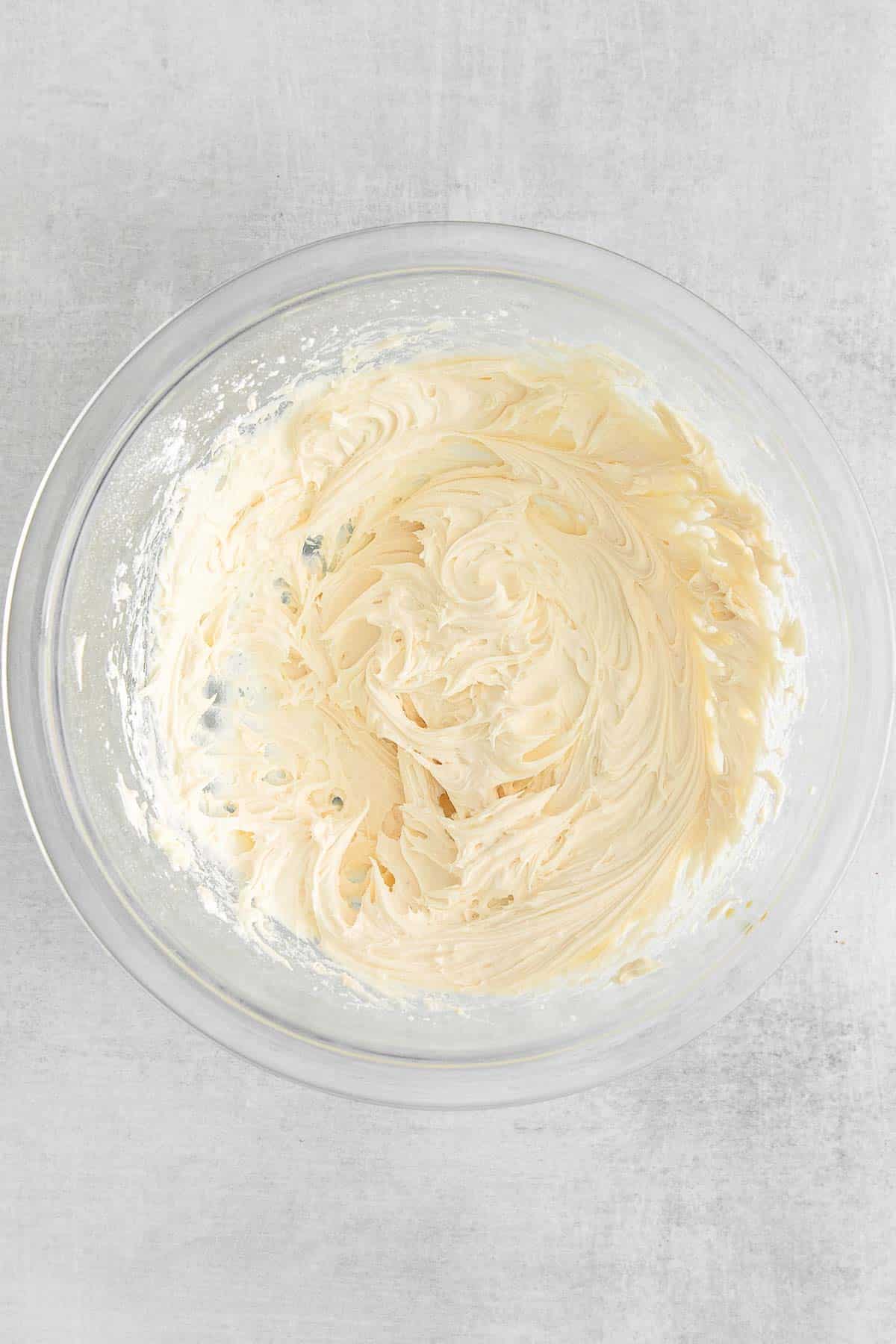Frosting mixture in a glass bowl.