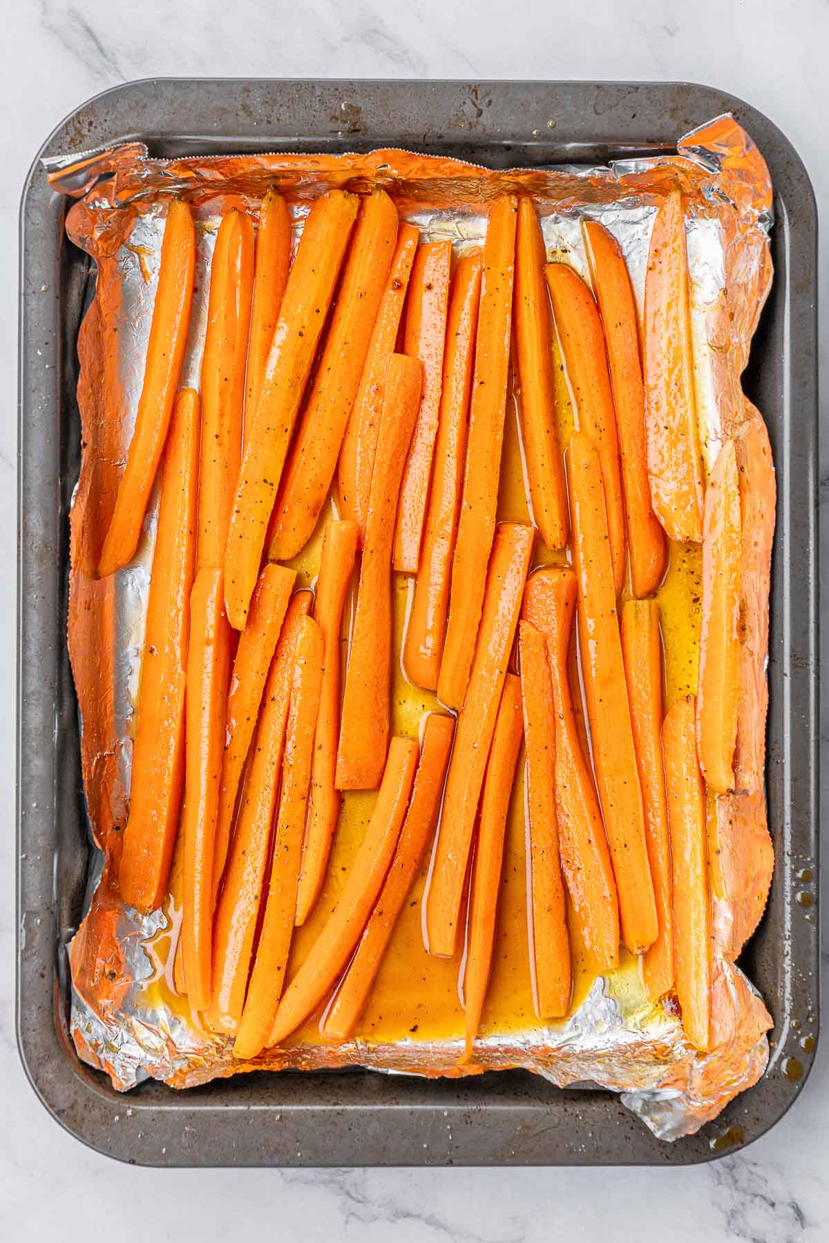 Glazed carrot slices on a baking sheet.