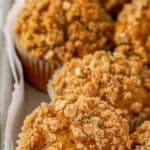 Multiple pumpkin oat muffins on a baking sheet with crumb topping.