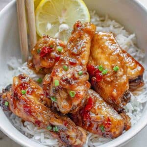 Thai chicken wings in a white bowl with rice.