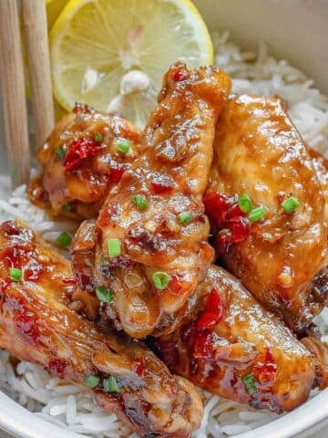 Thai chicken wings in a white bowl with rice.