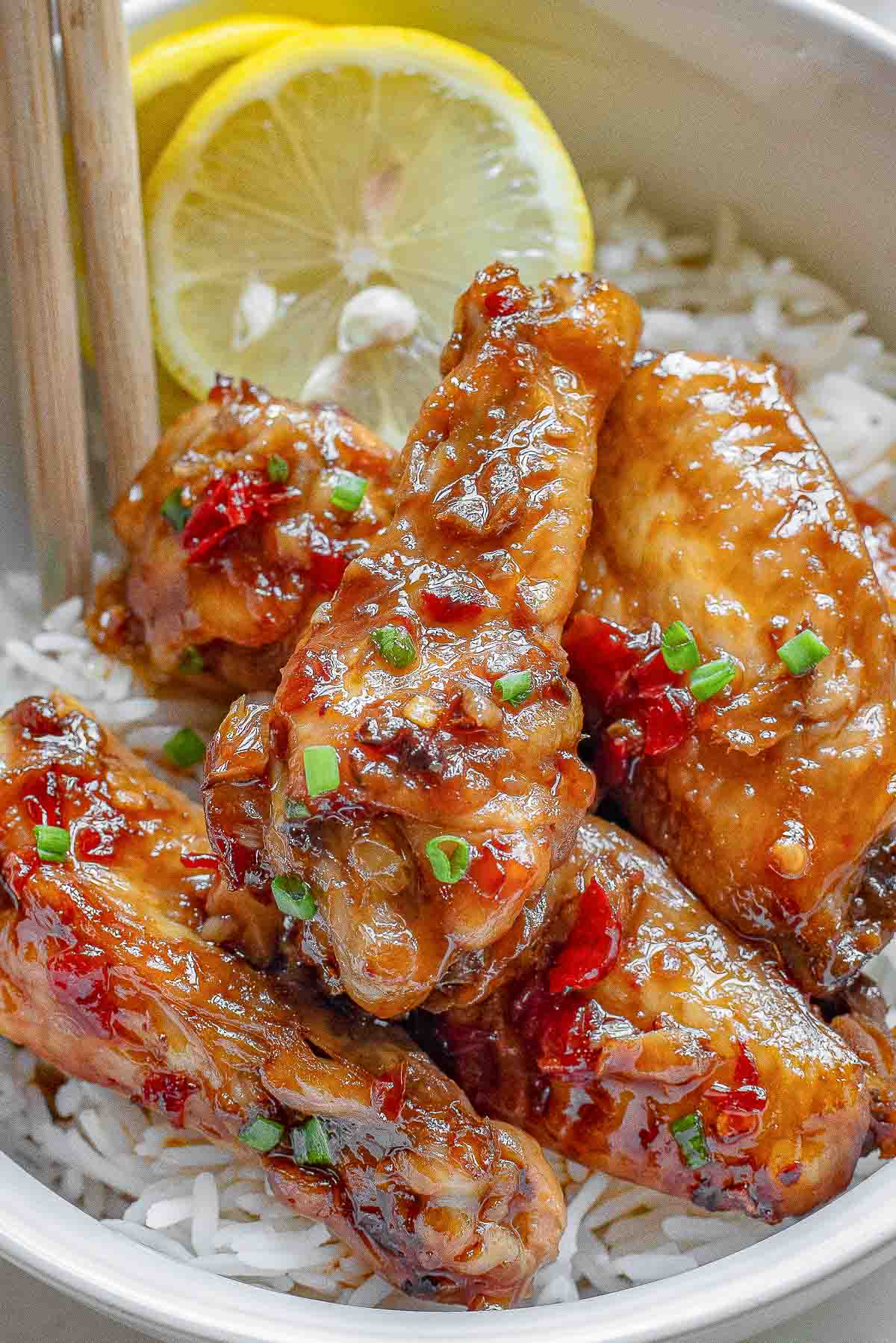 Thai chicken wings in a white bowl with rice.