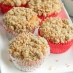 Apple cinnamon muffins with streusel topping on a white plate.