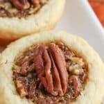 closeup of a pecan pie cookie on a white plate.