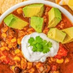 white bowl full of pumpkin chili with diced avocado and sour cream with text overlay that reads Easy pumpkin Chili